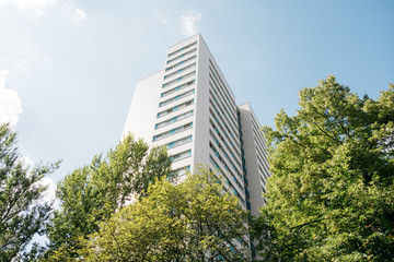 modern plattenbau skyscraper framed by green trees at germany