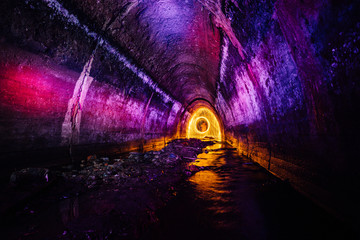 Sewer tunnel illuminated by color lanterns and freezelight using spinning burning steel wool and pyrotechnics