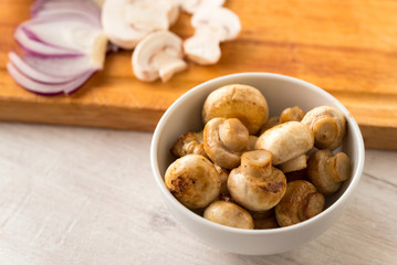 Fried champignon mushrooms in a bowl on the table.
