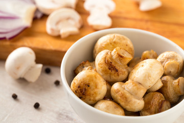 Fried champignon mushrooms in a bowl on the table.