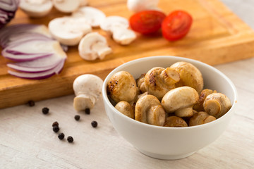 Fried champignon mushrooms in a bowl on the table.