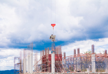 crane lifting concrete mixer container and worker in construction building  site workplace. on sky...