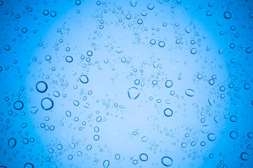 Rain droplets on blue glass background, Water drops on glass.