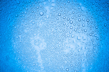 Rain droplets on blue glass background, Water drops on glass.
