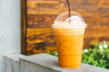 Cold iced Thai Tea, wooden background