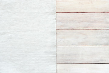 White velvet material and grunge wood board texture background. Surface of aged white wooden planks and striped texture fabric, top view, empty place.