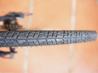 Top view bike black dirty tire, with orange tile floor background