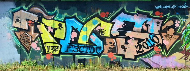 The old wall, painted in color graffiti drawing with aerosol paints. Background image on the theme of drawing graffiti and street art © mehaniq41