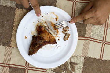 eating stake from plate with fork and knife man hands
