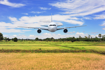 Airplane frying over the green flied 