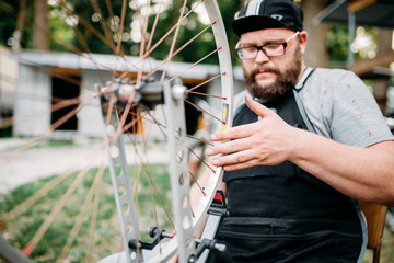 Mechanic adjusts bike spokes and repair wheel