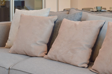 Fototapeta na wymiar Light brown, beige and gray pillows setting on sofa in living room