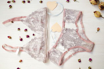 Lace lingerie on the white wooden background. Women's fashion underwear with dried roses