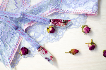 Lace lingerie on the white wooden background. Women's fashion underwear with dried roses