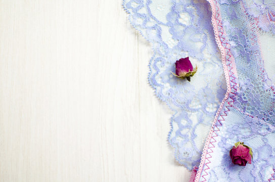 Lace lingerie on the white wooden background. Women's fashion underwear with dried roses