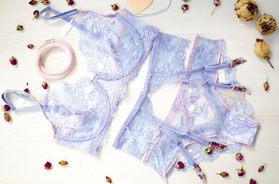Lace lingerie on the white wooden background. Women's fashion underwear with dried roses