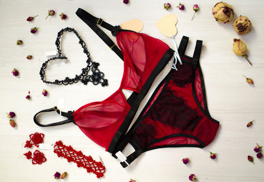 Female beauty underwear on the white wooden background. Fashion lace lingerie with dried roses and women accessories