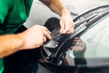 Worker hands installs car paint protection film