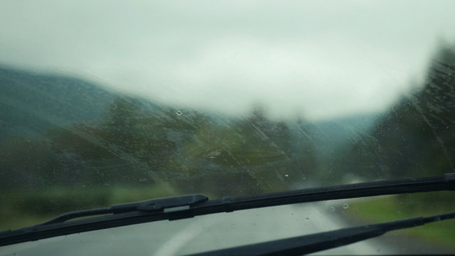 Car Wipers Removing Heavy Rain From The Windshield During Ride In The Mountains.