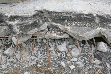 smashed old asphalt rubble and rusty rebar steel.