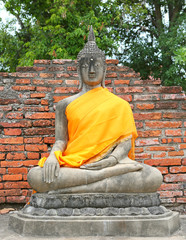 Statue of Buddha, wearing in yellow sacred fabric clothing called the robe of Buddhist Monk.