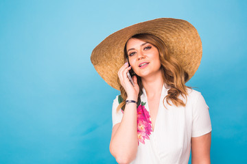 Young beautiful female talking on cell phone on blue background