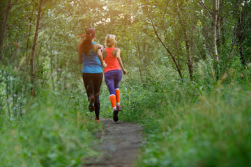 Obraz premium Two athletes run through forest