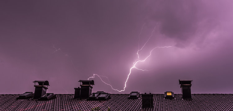 Blitzeinschlag über Häuserdach, Breitbild