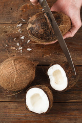 Coconuts cut on brown wooden background. Delicious tropical fruit with fresh white pulp