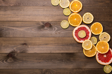 Fototapeta na wymiar Citrus fruits. Oranges, limes and lemons. Over wood table background with copy space