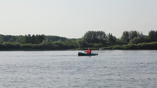 man in the boat with oars floating on the river