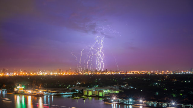 Scenery from Chao Phraya River viewing scary lightning strike from cloud to ground at night , Bangkok , Thailand