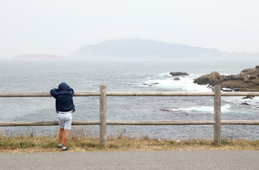 niño mirando al mar en un día con niebla