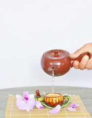 Pouring hot tea into cup.