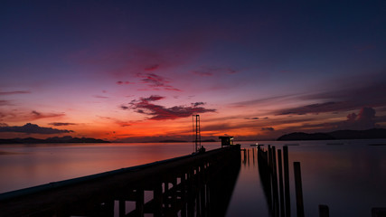 Obraz premium scenery view of old jetty to the sea beautiful sunrise or sunset in phuket thailand.