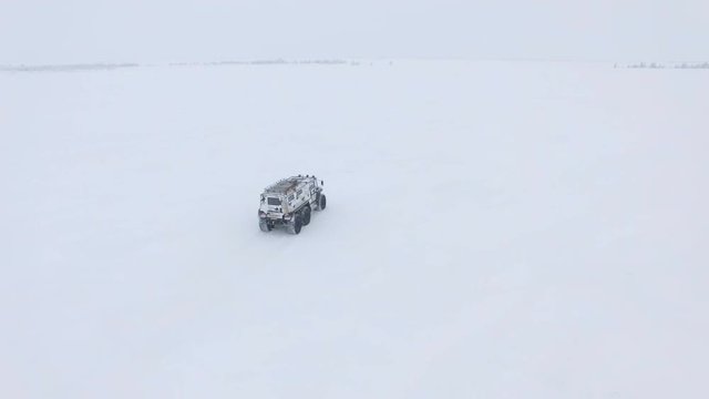 Flycam Follows Outlander Driving along Snow-Covered Territory