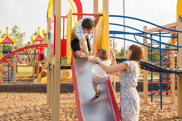 The little boy happy outdoors in playground with his parents