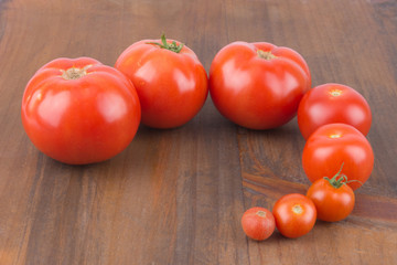 In Reihe gelegte unterschiedlich großer Tomaten auf Holzbrett