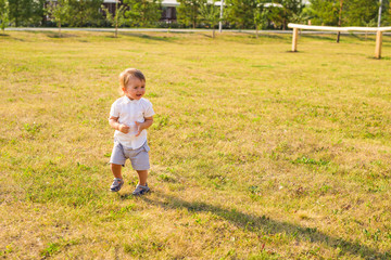 Portrait of cute little baby boy having fun outside. Smiling happy child playing outdoors