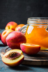 Spiced golden plum jam in a glass jar. Selective focus, space for text.