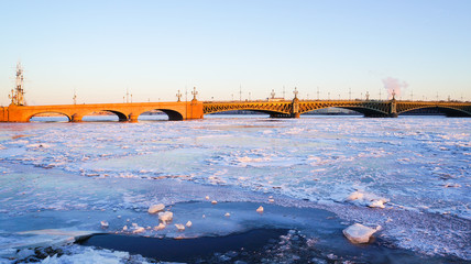 Fototapeta na wymiar Winter landscape with the setting sun and the ice on the river. Winter In Saint Petersburg. The Neva river to the Peter and Paul fortress. 