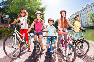 Obraz premium Children with bicycles on embankment of the river