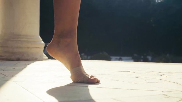 Bare feet of a woman dancing on a stone floor