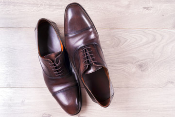 Male fashion with shoes on wooden background.