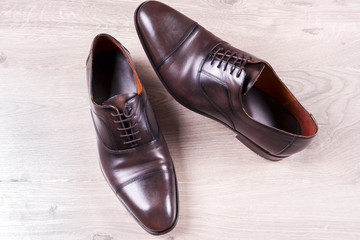 Male fashion with shoes on wooden background.