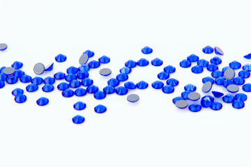 Precious sparkling rhinestones sapphire colors on a white background.