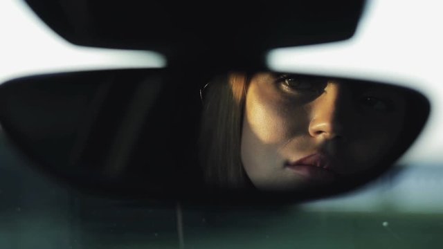 Luxury Woman Looking To Her Face In Rearview Mirror Of Her Car