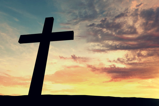 Religious cross silhouette against a bight sunrise sky. 3D Rendering