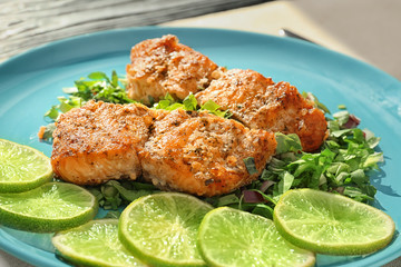 Plate with delicious salmon, sliced lime and herbs, closeup