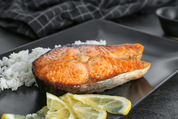 Delicious roasted salmon steak with rice on plate